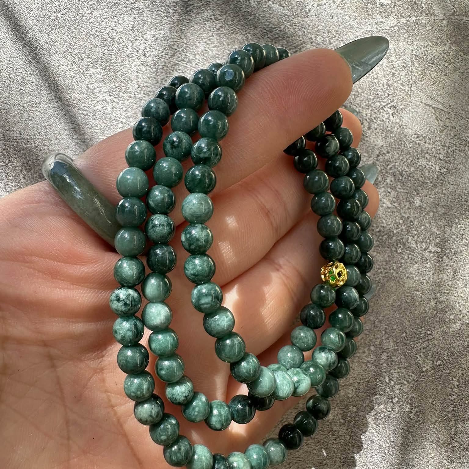 Chuỗi cổ cẩm thạch phối charm vàng trên tay